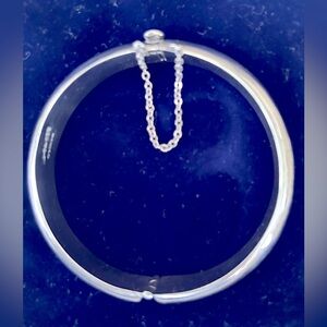 Bracelet. Silver hinged bangle bracelet from Mexico. Clasp with chain attached.